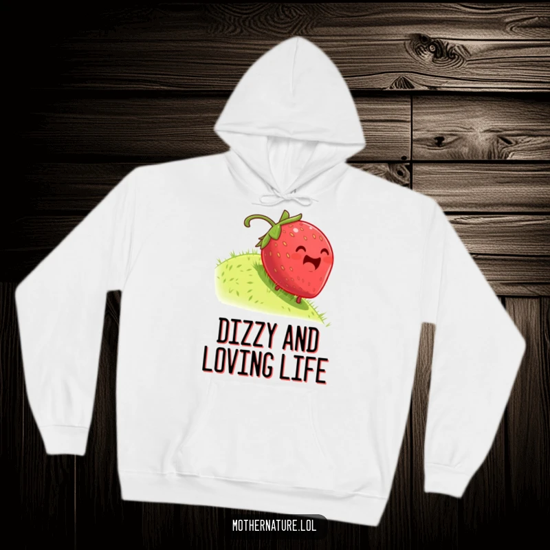 Funny hoodie illustrating a plump, dizzy strawberry gleefully rolling down a grassy hill; a symbol of pure, uninhibited joy.