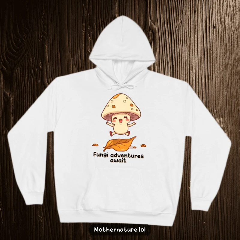 Funny hoodie with a cheerful mushroom character with little legs leaping over a fallen leaf; a cozy, whimsical design.